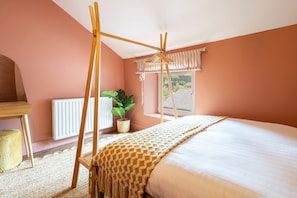 A bedroom with a four-poster bed, a radiator, a potted plant, and a window with a view of the outside. - Host Stay Bankfoot Cottage (Newcastle-upon-Tyne)