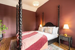 A four-poster bed with a dark wooden frame, a red and white striped bedspread, and two bedside lamps. - Host Stay Bankfoot Cottage (Newcastle-upon-Tyne)