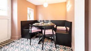 A dining area with a round table, black chairs, and a checkered tablecloth. - Host Stay Bankfoot Cottage (Newcastle-upon-Tyne)
