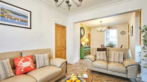 A living room with two beige sofas, a coffee table with fruit, and a framed picture on the wall. - Host Stay Sunstar (Whitby)