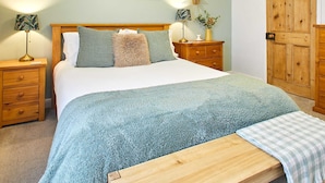 A bedroom with a bed, bedside tables, a nightstand, a wooden bench, a wall-mounted star decoration, and framed botanical illustrations. - Host Stay Sunstar (Whitby)