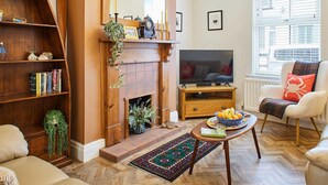 A living room with a fireplace, a television, a bookshelf, and a comfortable seating area. - Host Stay Sunstar (Whitby)