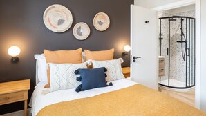 A bedroom with a bed, bedside tables, and a shower area. - Host Stay The School House (Hereford)