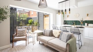 A modern kitchen with white cabinets, a green backsplash, and pendant lighting. - Host Stay The School House (Hereford)