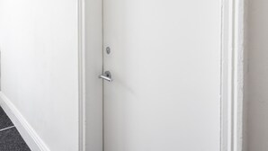 A white door with a number 1 sign above it, a door handle, and a keyhole. - Host Stay Clifton Studio 1 (Darlington)