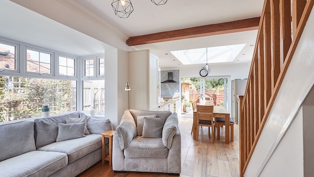 A spacious living area with a grey sofa, a grey armchair, and a wooden dining table. - Host Stay Bankside Cottage (Saltburn-by-the-Sea)