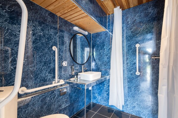 A bathroom with a marble wall, a sink, a mirror, and a shower curtain. - Host Stay Crackin View (Hexham)