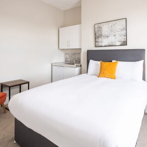 A hotel room with a large bed, a small desk, and a bathroom. - Host Stay Clifton Studio 4 (Darlington)