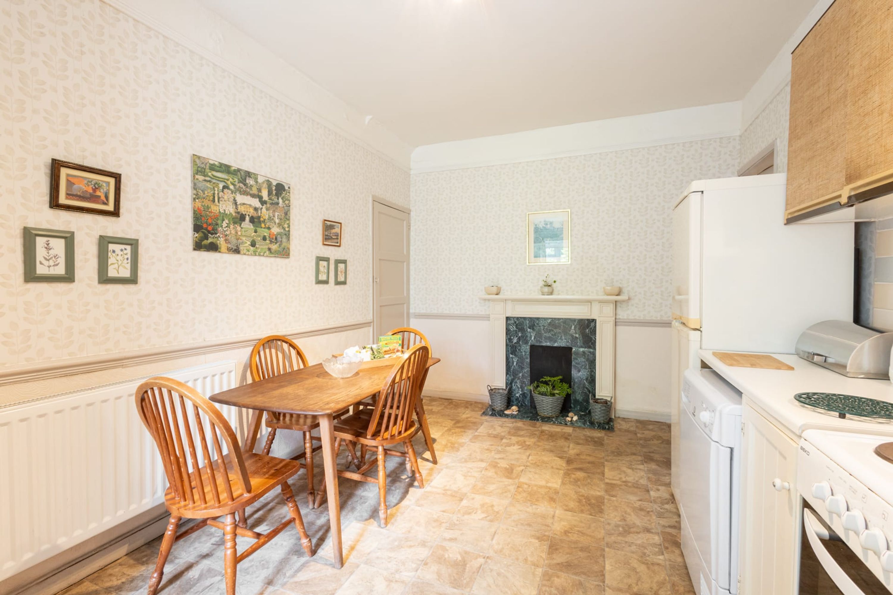 A kitchen with a dining table and chairs, a fireplace, and a washing machine.
