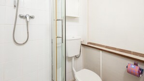 A bathroom with a glass-enclosed shower, a toilet, and a shelf with a roll of toilet paper. - Host Stay Upper Lodge (Alnwick)