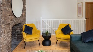 A modern living room with two yellow armchairs, a black coffee table, and a green sofa. - Host Stay Princes Place Hideaway I (Liverpool)
