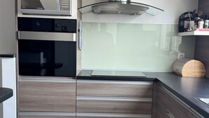 A modern kitchen with built-in appliances, a stainless steel range hood, and a checkered tile floor. - Spacious 2-bedroom apartment in fabulous Zadar with WiFi, AC, free parking (Zadar)