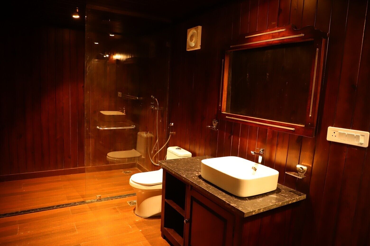 Une petite salle de bain comprenant des toilettes, une douche et un lavabo.