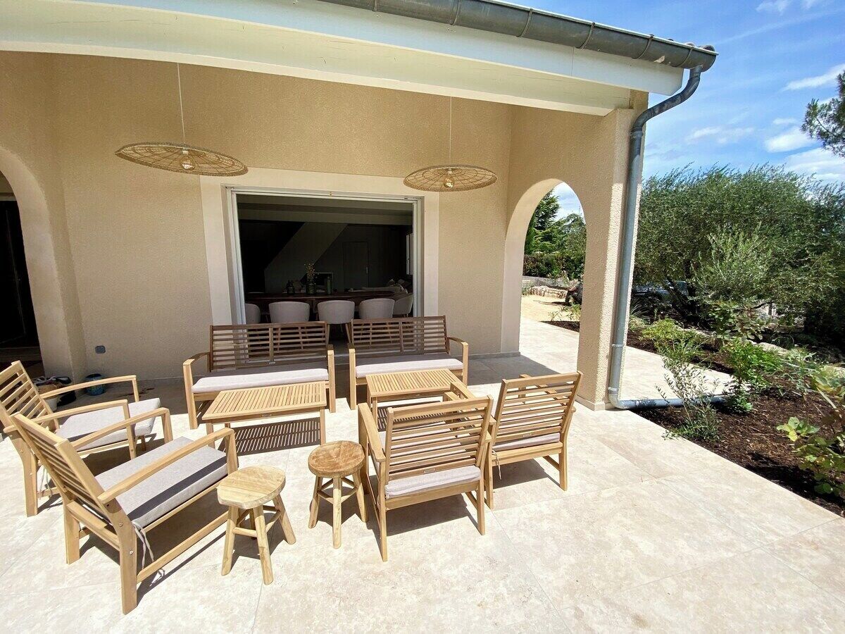Un patio al aire libre con muebles de madera y una zona de estar cubierta.