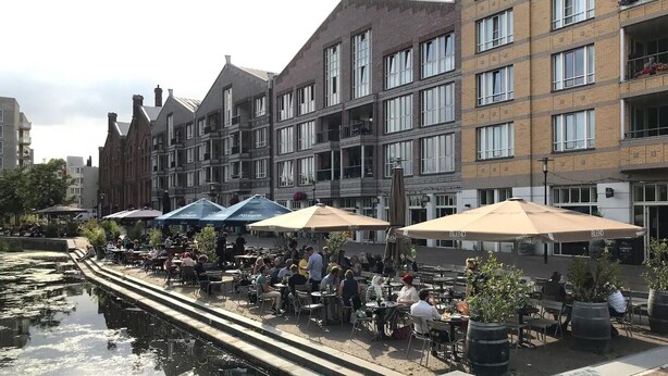 A canal-side café with outdoor seating, surrounded by historic buildings. - AMSTERDAM TOWN HOUSE WITH PRIVATE GARDEN & PARKING (Amsterdam)