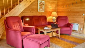 A cozy room with a wooden interior, a sofa set, a table with a laptop, and a lamp. - Find With Nr 509 Your Holiday Home in the Harz Mountains (Oberharz am Brocken)