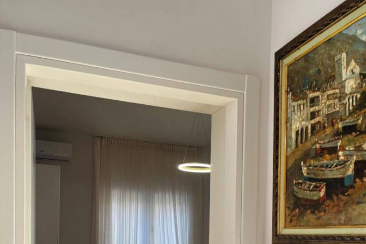 Une chambre à coucher avec un lit, une fenêtre avec des rideaux et un tableau accroché au mur.