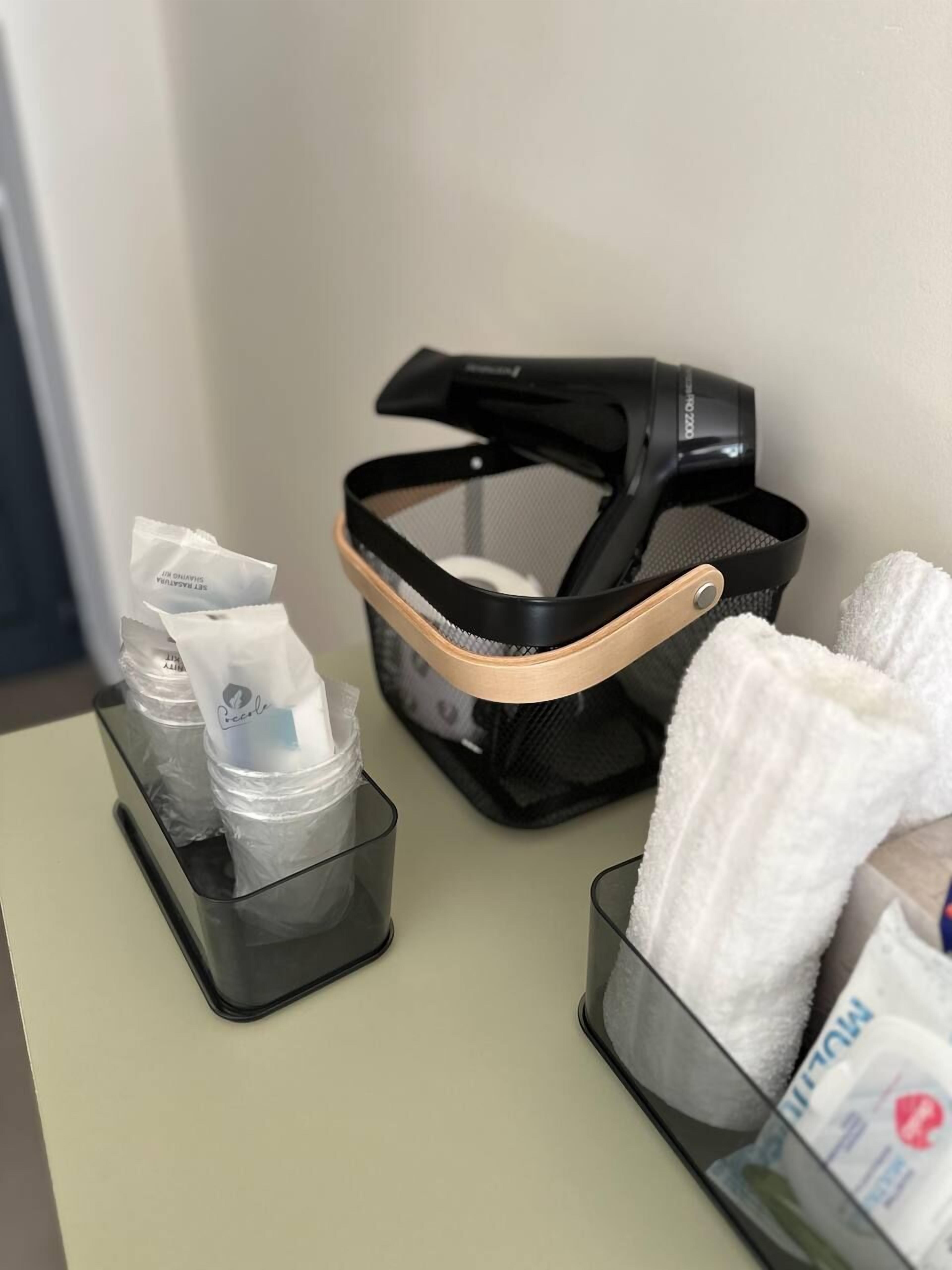 Una habitación de hotel con un calentador portátil negro, una caja de pañuelos y un rollo de papel de seda sobre una mesa.