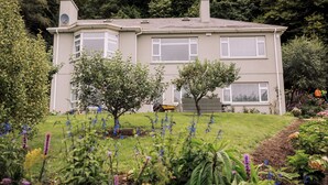 Une maison à deux étages avec un jardin à l’avant.