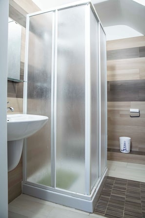 A modern bathroom with a glass-enclosed shower, a white sink, and a tiled shower area. - B&B Golfo incantato - Bisceglie (Bisceglie)