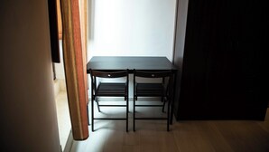 A room with a dark wooden table and chairs, a white wall, and a wooden floor. - B&B Golfo incantato - Bisceglie (Bisceglie)