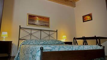 Une chambre à coucher avec un lit, deux lampes de chevet et deux tableaux au mur.