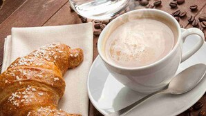 A croissant and a cup of coffee on a wooden table. - B&B Golfo incantato - Bisceglie (Bisceglie)
