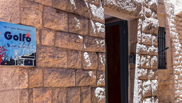 A stone building with a sign for 'Golfo' offering bed and breakfast, a wooden bench, and a door. - B&B Golfo incantato - Bisceglie (Bisceglie)