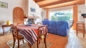 Un comedor con mesa de madera, sillas y sofá azul.
