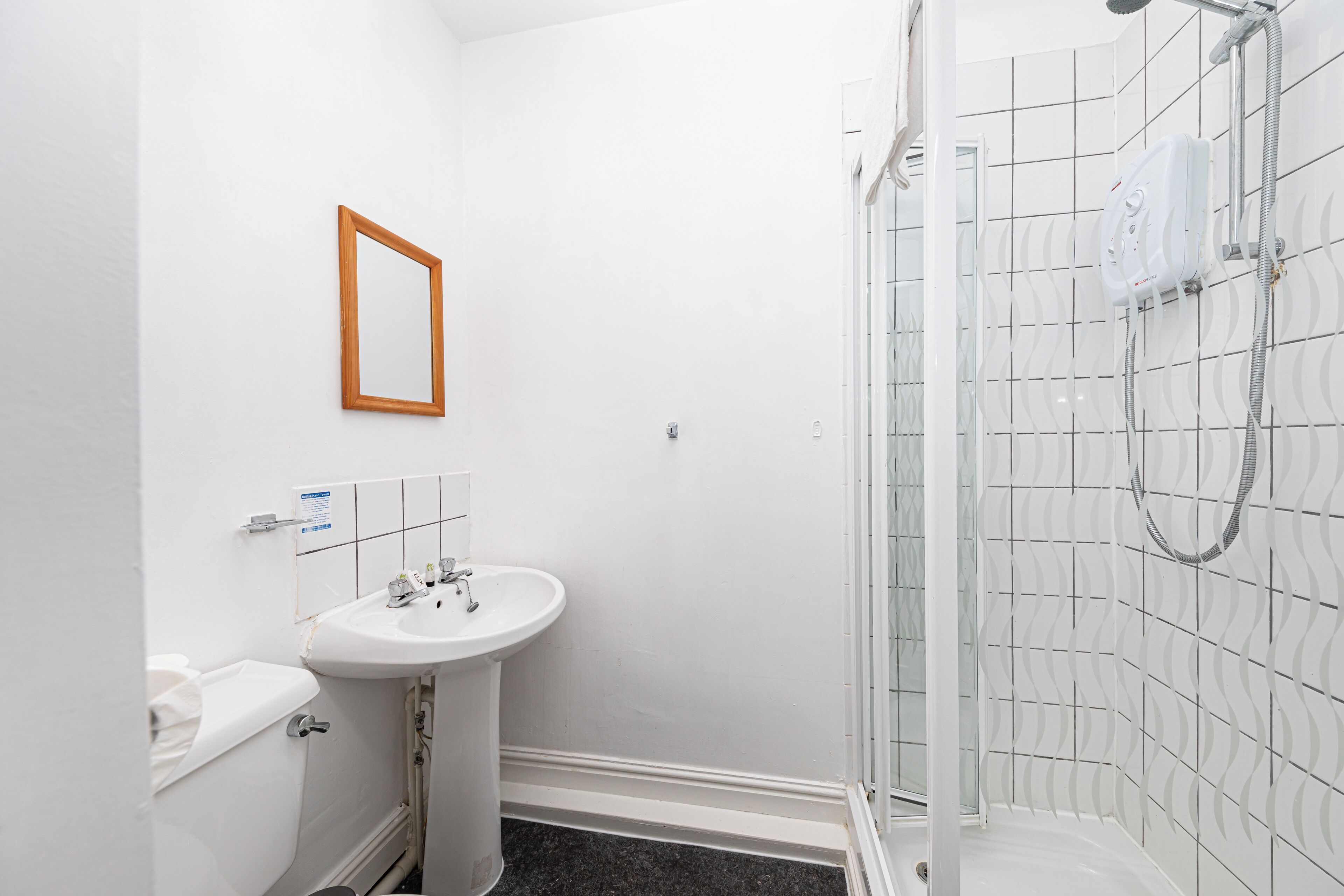 A bathroom with a sink, toilet, and shower.
