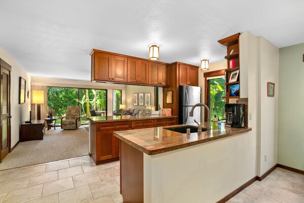 A spacious kitchen with wooden cabinets, a granite countertop, and a large island.