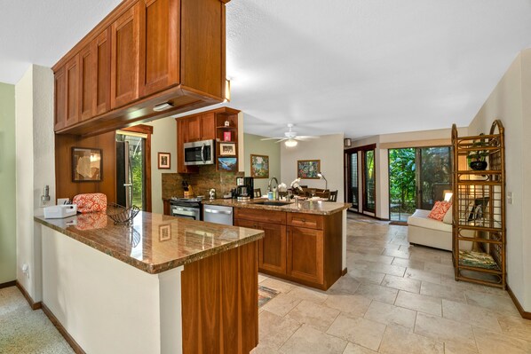 Una cocina amplia con gabinetes de madera, encimeras de granito y una isla grande.