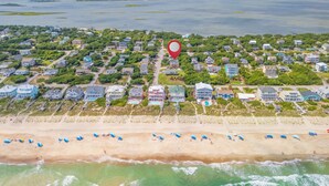 An aerial view of a coastal residential area with houses, a beach, and a large body of water. - Hot Mess - Pool, Oceanview, Pet-Friendly Home (Emerald Isle)
