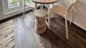 A dining area with a round wooden table, two white chairs, and a small potted plant. - Modern cozy studio near Montmartre, 2min walk to metro Château Rouge (Paris)