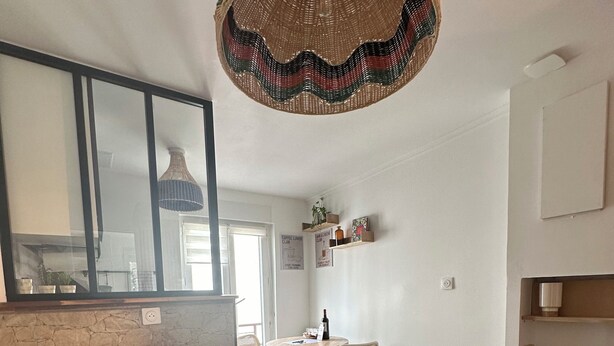 A modern living room with a sofa, a round coffee table, and a dining area with a table and chairs. - Modern cozy studio near Montmartre, 2min walk to metro Château Rouge (Paris)