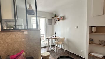 Un salon moderne comprenant un canapé, une table basse ronde et un coin repas avec une table et des chaises.