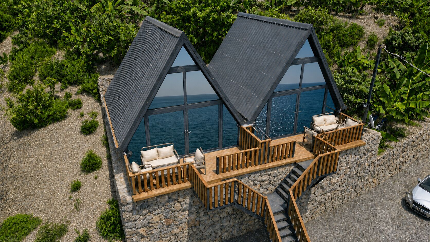 Ein zweistöckiges Gebäude mit Balkon, Treppe und Blick auf das Meer.