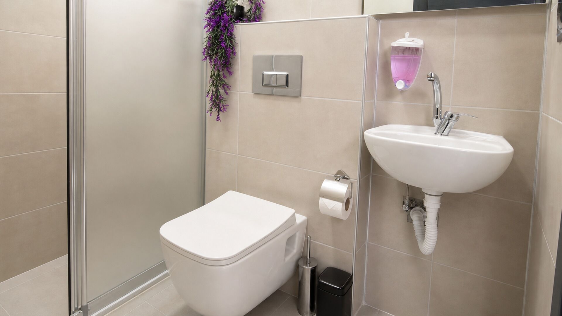 Un baño moderno con inodoro, lavamanos y ducha.