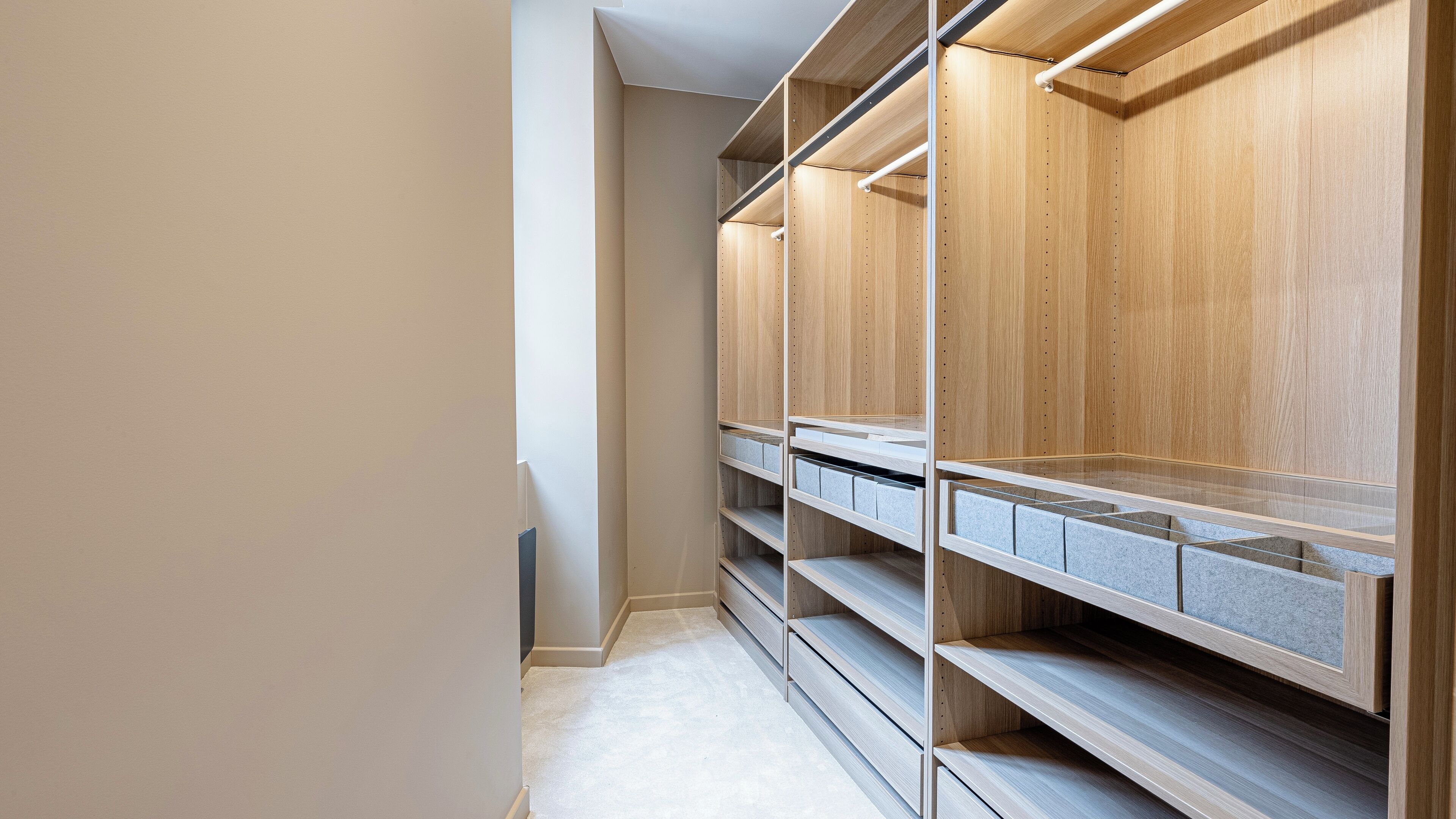Un dressing avec de nombreuses étagères et tiroirs en bois.