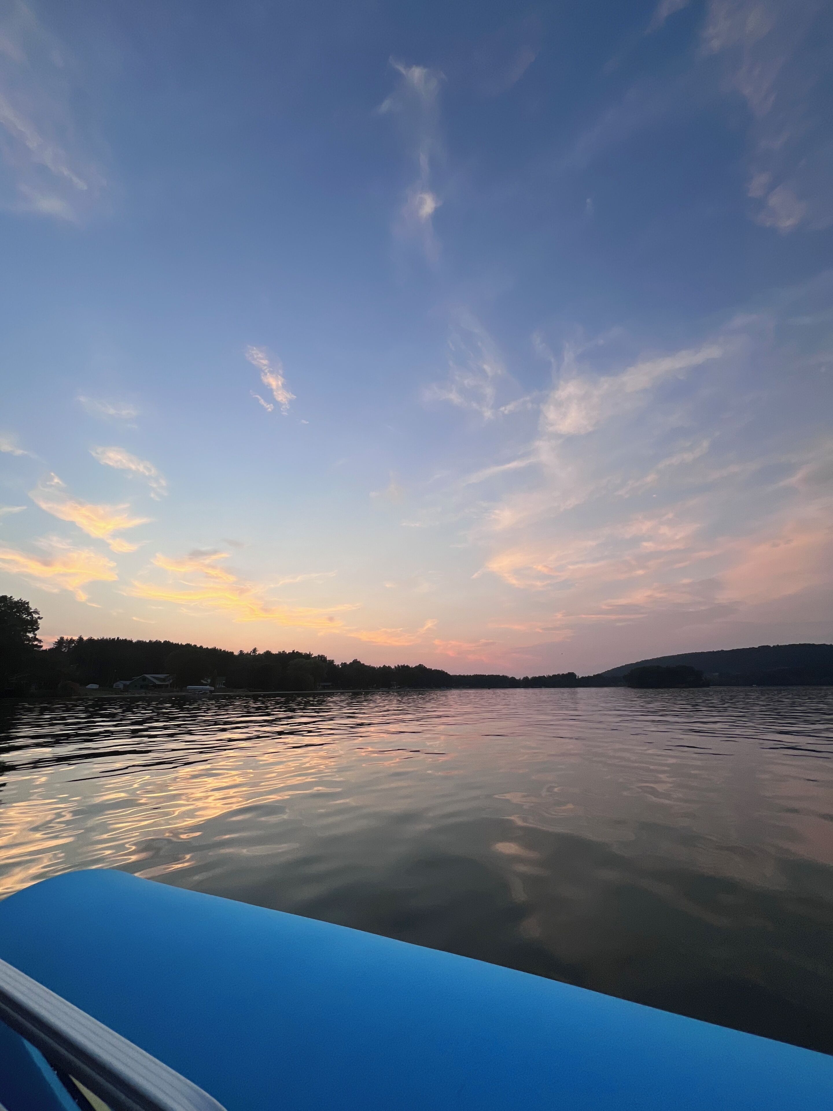 A calm lake with a clear sky and distant trees.