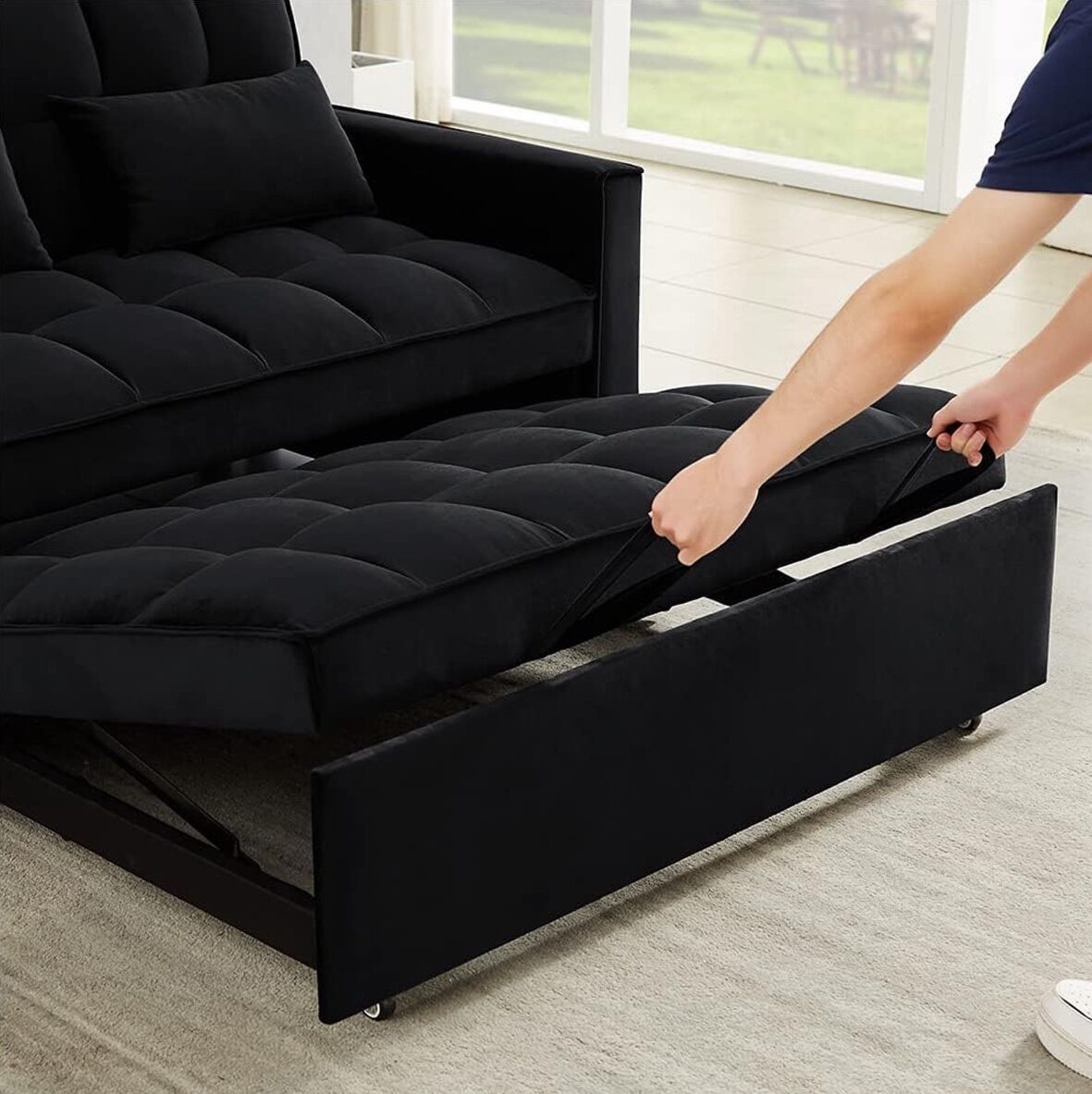 A black sofa with a hidden storage compartment being pulled out.