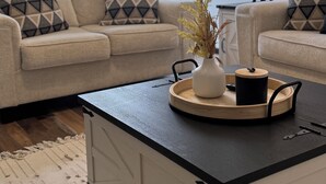 Un salon comprenant un canapé, une table basse et une lampe.