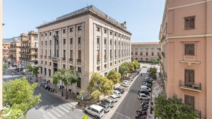 A multi-story building with a classical architectural style, featuring a central courtyard with trees and parked cars. - Casa Finocchiaro by Wonderful Italy (Palermo)