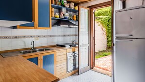 Une cuisine avec des meubles en bois, un évier en acier inoxydable et un four encastré.