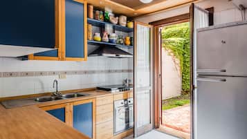 Una cocina con armarios de madera, un lavamanos de acero inoxidable y un horno empotrado.