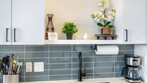 A kitchen with a coffee maker, a potted plant, and a sign about no smoking or vaping. - Chic Condo Minutes to Downtown, Gruene, & More (New Braunfels)