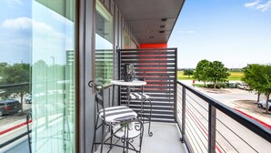 A balcony with a view of a parking area and greenery. - Chic Condo Minutes to Downtown, Gruene, & More (New Braunfels)