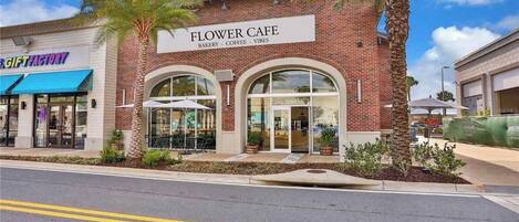 Un edificio con un letrero que dice "Flower Cafe" y "Panadería - Café - Ambiente".