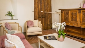 A living room with a beige sofa, a wooden cabinet, and a chessboard on a table.