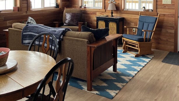 A cozy cabin interior with wooden walls, a mounted deer head, a television, and a fireplace. - Welcome to The Fox Farm cabin  (Genoa)